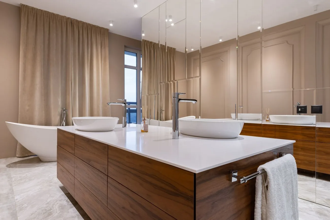 A luxury bathroom with a freestanding bath and walnut vanity