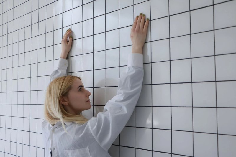 A fitter setting wall tiles by hand