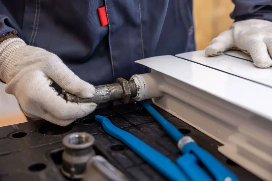 Gloved hands fitting plumbing connections